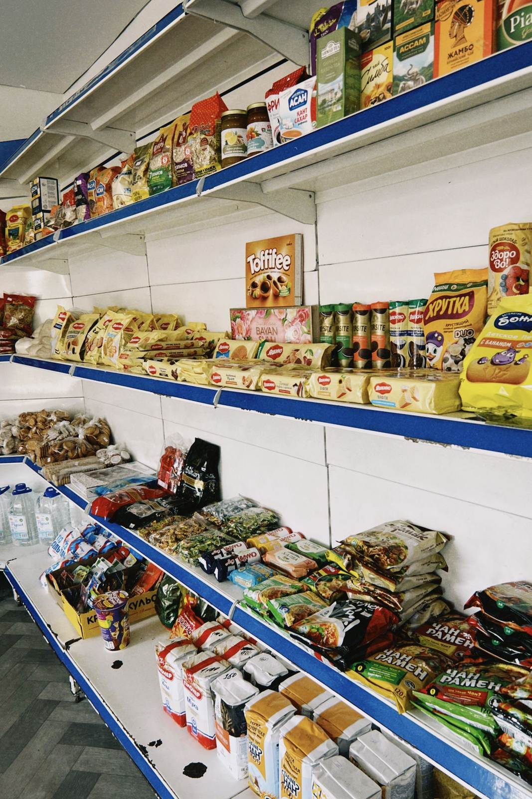 Colorful assortment of packaged grocery items displayed on shelves in a Kazakhstan store