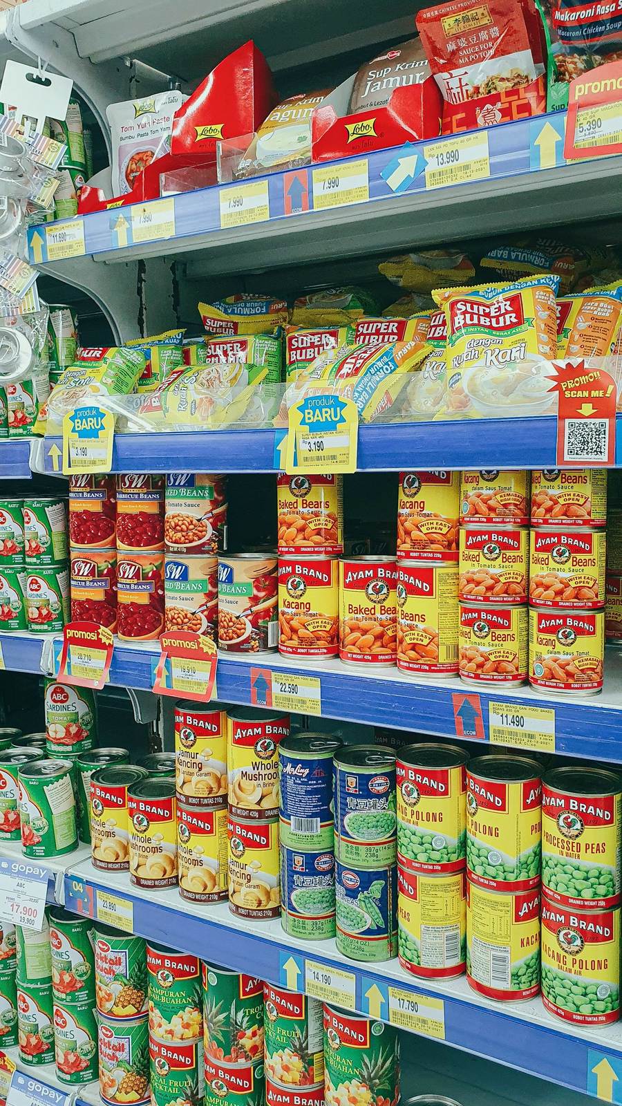 Canned and packaged goods neatly arranged on grocery store shelves, showcasing diverse food products